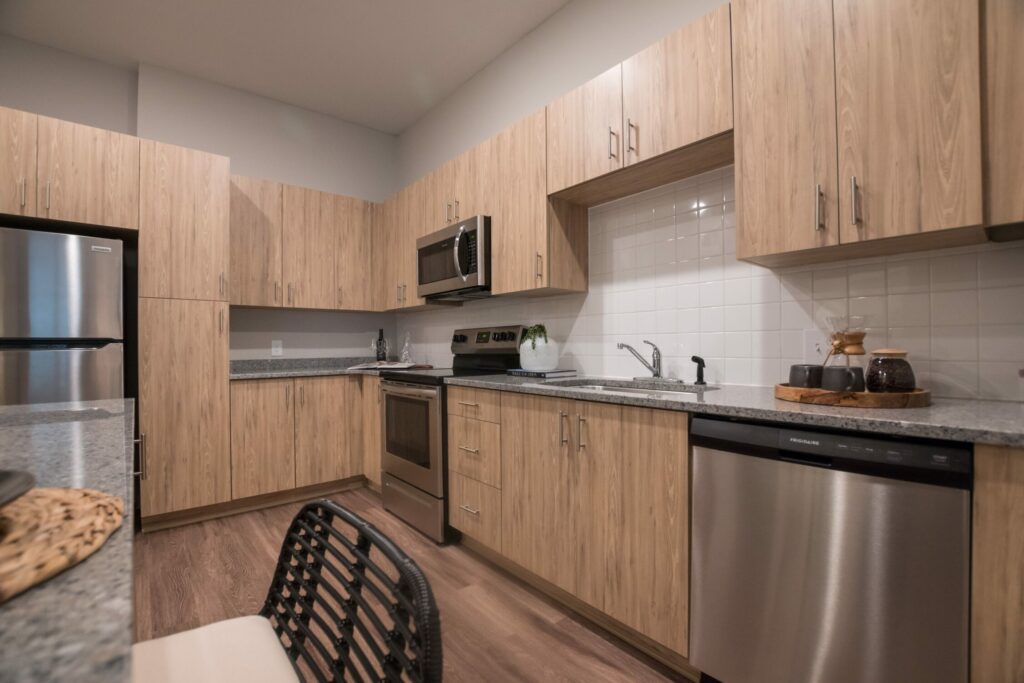 An Environment Where You Can Flourish - kitchen interior with granite countertops, chef's island, and kitchen pantries